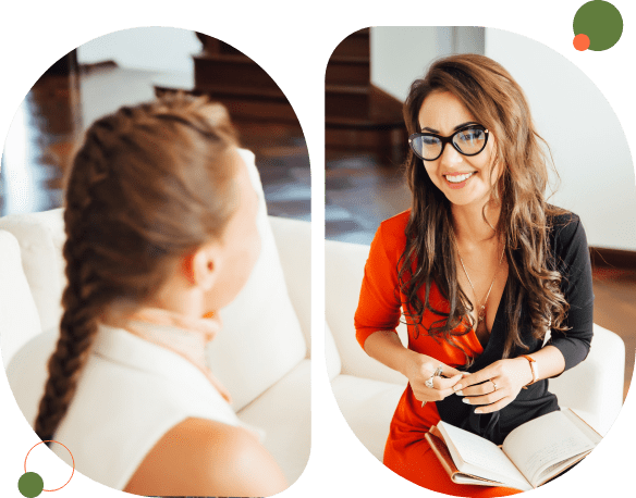Two women engaged in a friendly conversation indoors.
