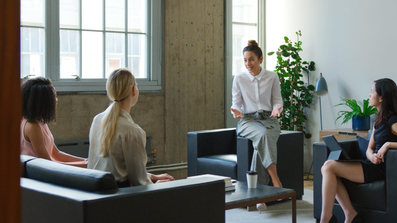 Two women in a modern office having a conversation.